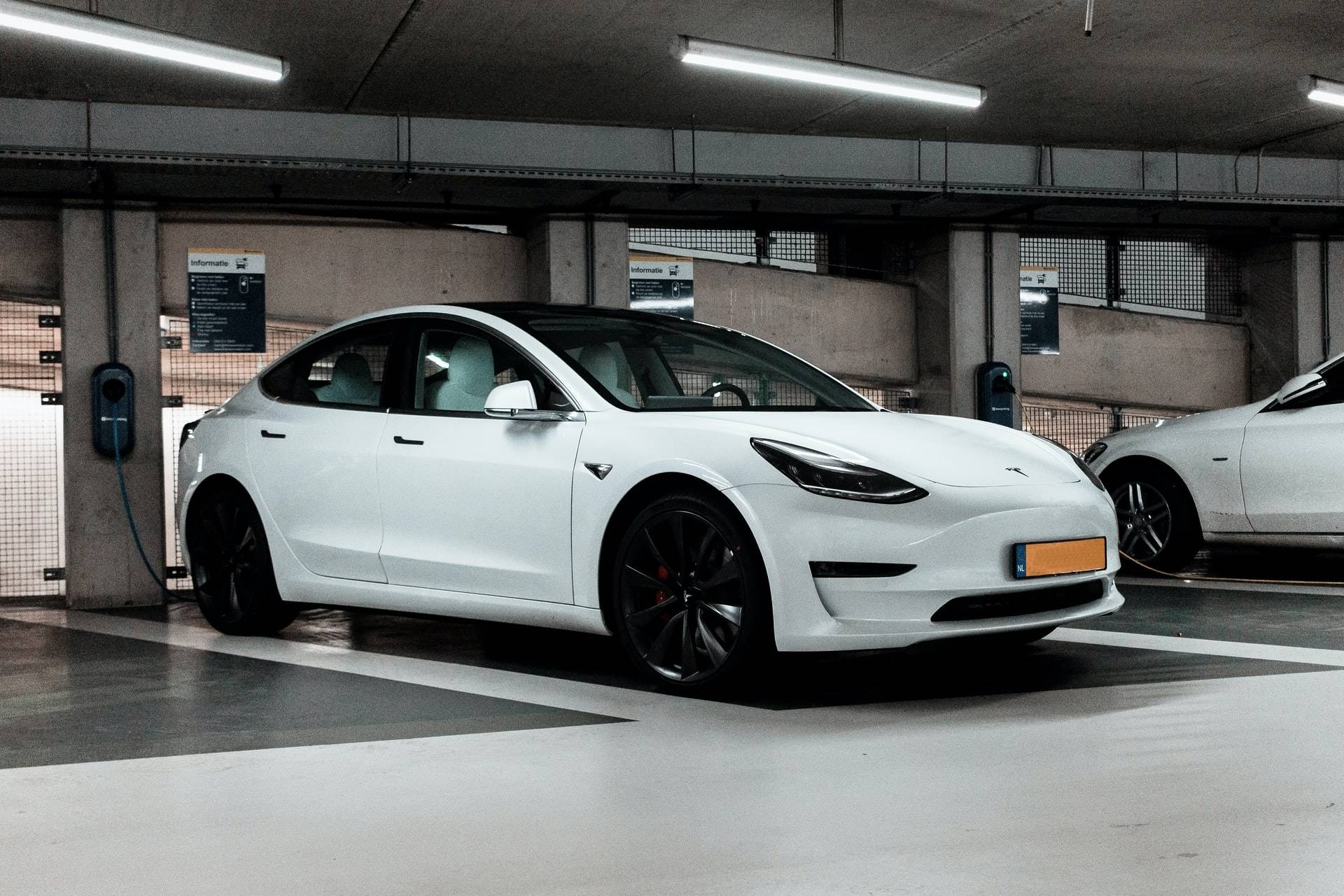 White Tesla parked and charging