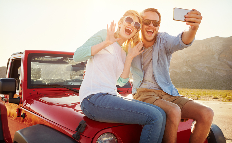 Couple sitting on a rental car from Easirent